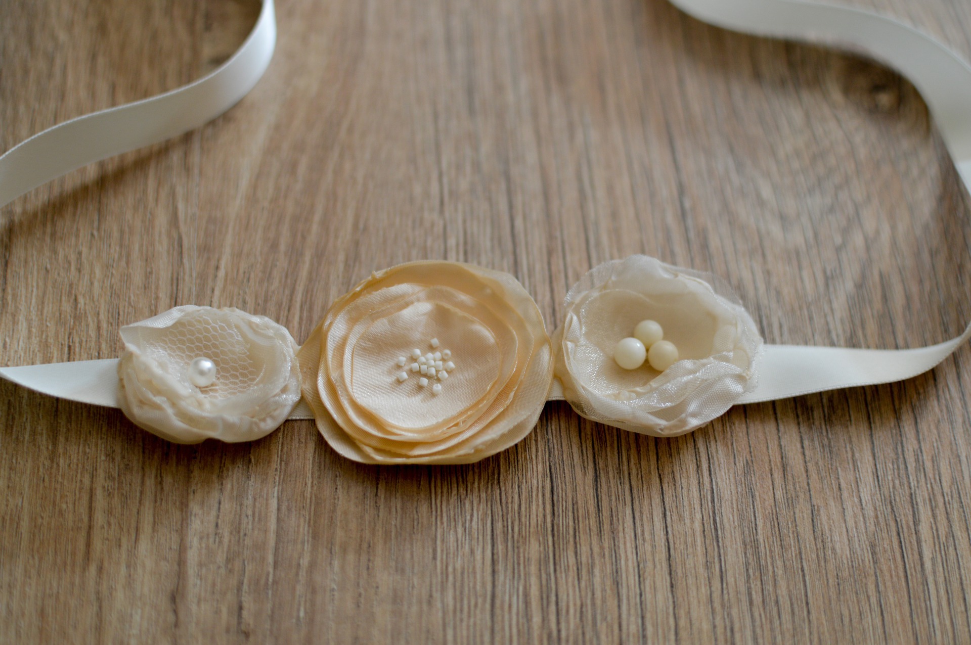 Headband à fleurs en tissus et perles crème et saumon pour bébé et petite fille