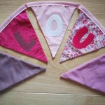 Guirlande de fanions en tissus (fushia, parme, violet foncé et rose) et personnalisable avec prénom